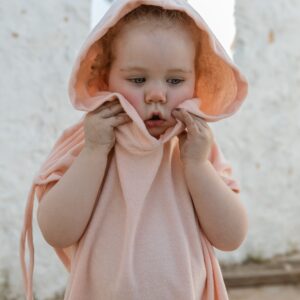 A little girl wearing a Sorbet Summer - Summer Poncho.