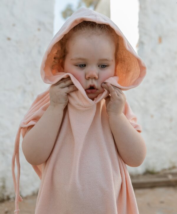 A little girl wearing a Sorbet Summer - Summer Poncho.