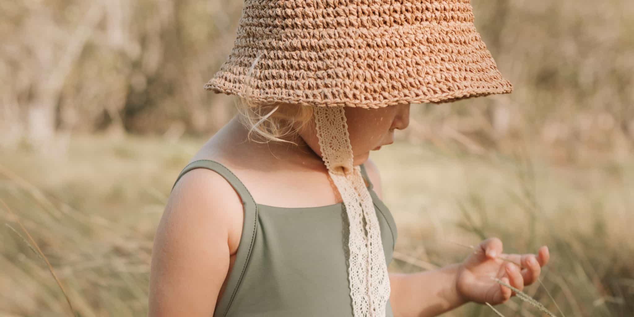 A child wearing sustainable swimwear and a hat.